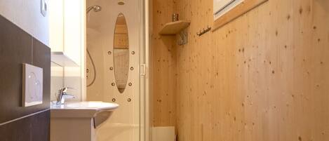 A compact bathroom with a shower, toilet, and sink.