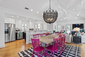 Una cocina moderna con muebles blancos, electrodomésticos de acero inoxidable y una isla central.
