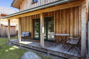 Une terrasse en bois avec des meubles d’extérieur et un patio couvert.