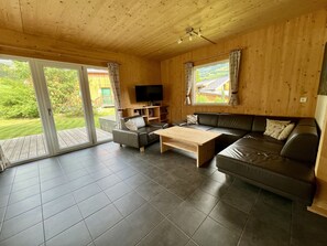 A wooden interior with a sofa, coffee table, and TV.