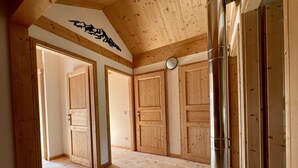 Ein Zimmer mit Holzböden, einer großen Metallstütze und Holztüren.