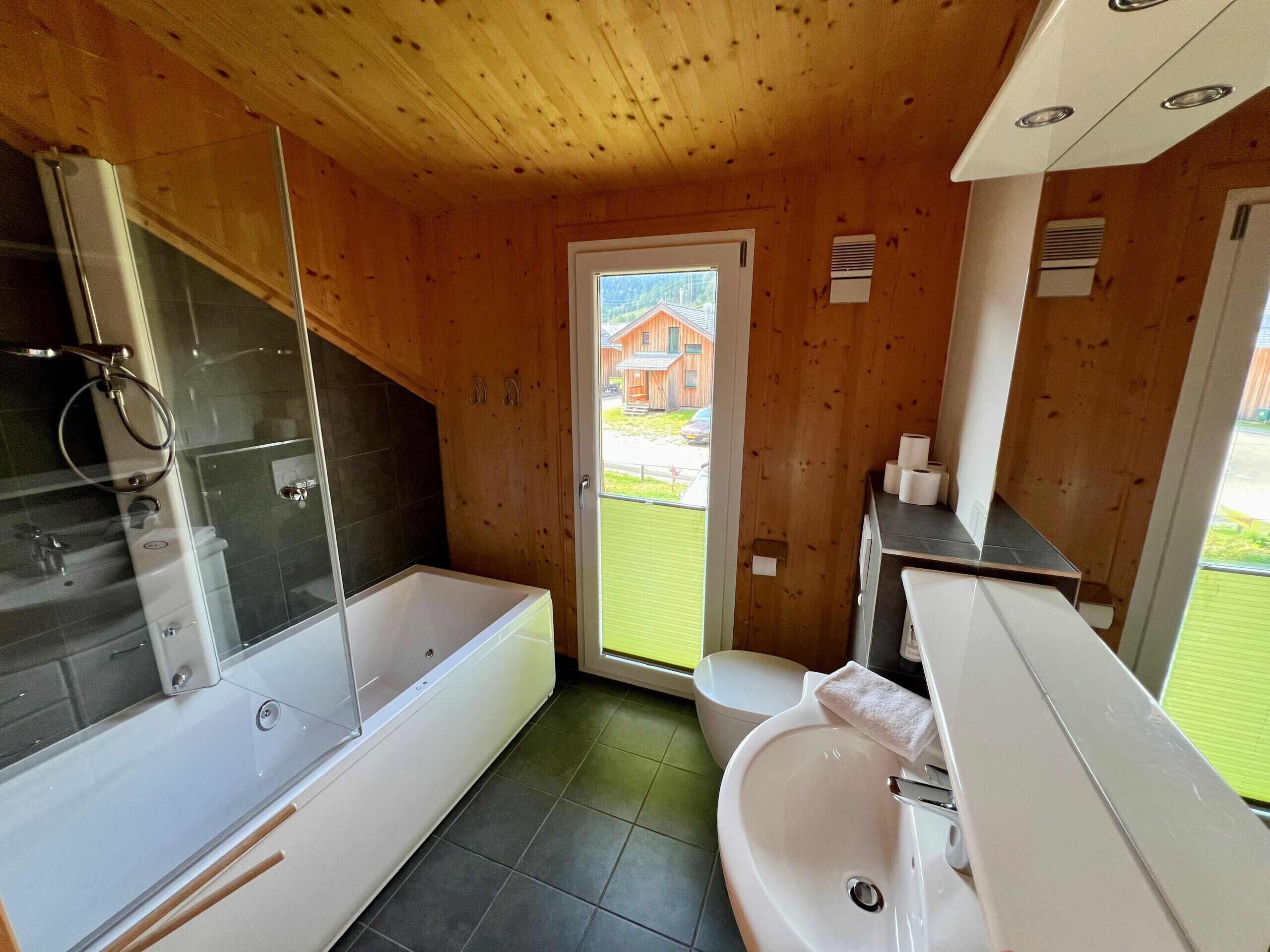 A modern bathroom with a bathtub, a sink, and a shower area.