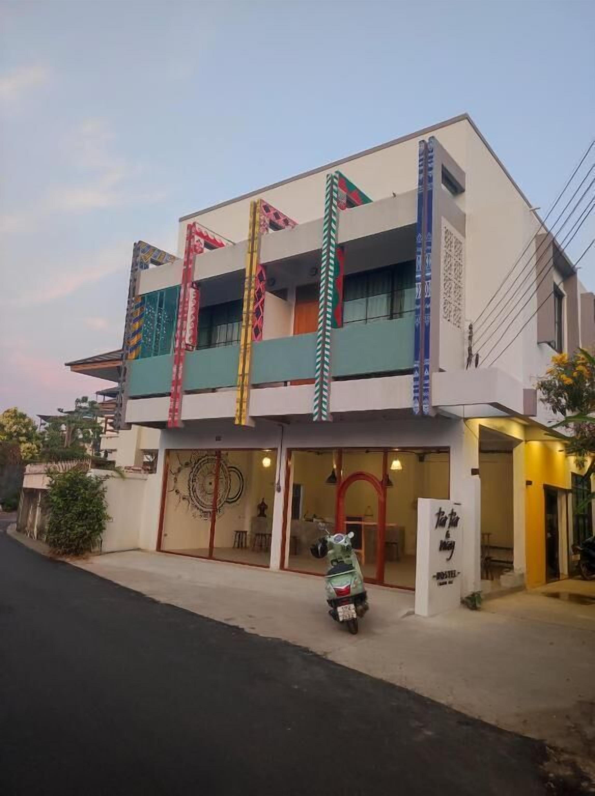 A modern building with a flat roof, large windows, and a signboard.