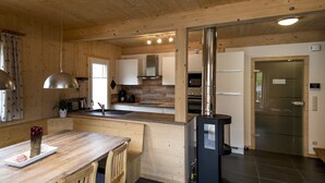 A modern kitchen with wooden cabinetry, a central island, and a black stove.