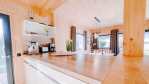 A modern kitchen with wooden cabinets, a countertop, and a coffee machine.