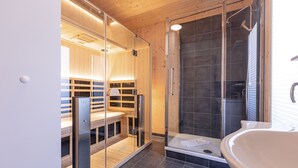 A modern bathroom with a glass shower enclosure, a freestanding bathtub, and wooden cabinetry. - Chalet # 49b with 4 Bedrooms, IR sauna & whirlpool (St. Georgen am Kreischberg)