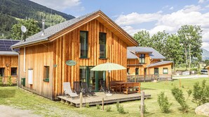 Une cabane en bois dotée d’une terrasse, de sièges extérieurs et d’une enseigne indiquant le nom « Katrin ».