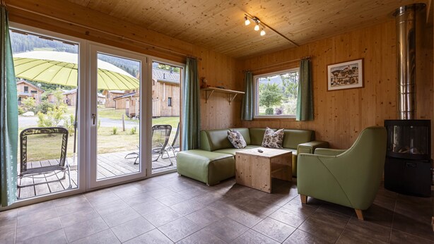 Une pièce chaleureuse avec un canapé vert, une petite table basse et une cheminée.