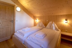 A room with two beds, wooden walls, and two wall-mounted lights. - Chalet # 13b with 4 Bedrooms, IR sauna & whirlpool (St. Georgen am Kreischberg)