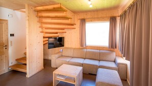 A wooden interior with a sofa, a TV, and a small table.