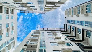 A high-rise building with multiple balconies and large windows, offering views of the sky. - One Madison Towers (Iloilo)
