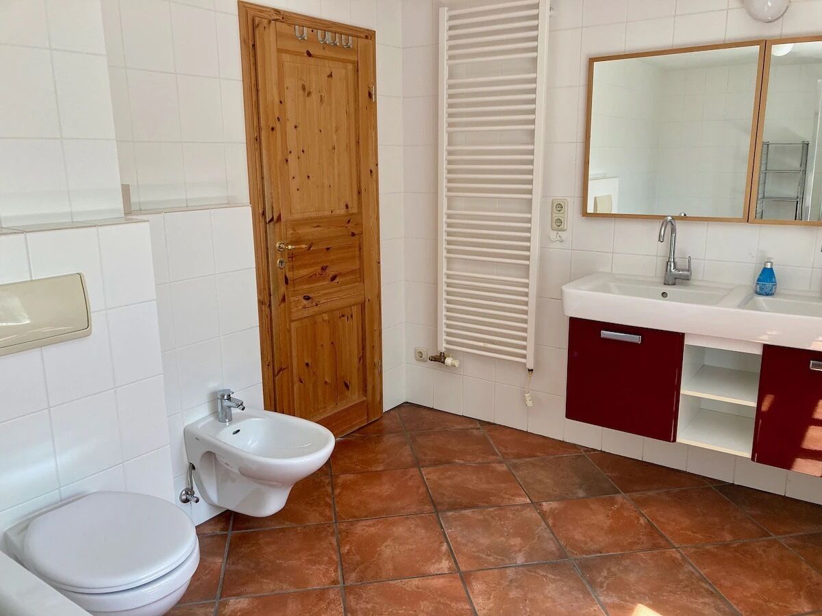 A bathroom with a toilet, bidet, and sink.