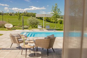 Piscine extérieure en saison, parasols, chaises longues
