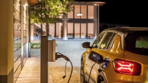 A yellow car parked at an electric vehicle charging station at night. - Tenuta Cà Bassa (Castel San Pietro Terme)