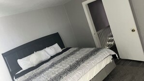 A bedroom with a bed, a door, and a ceiling light. - Charming 3-bedroom house with AC and WiFi in lovely Pittsburgh (Pittsburgh)