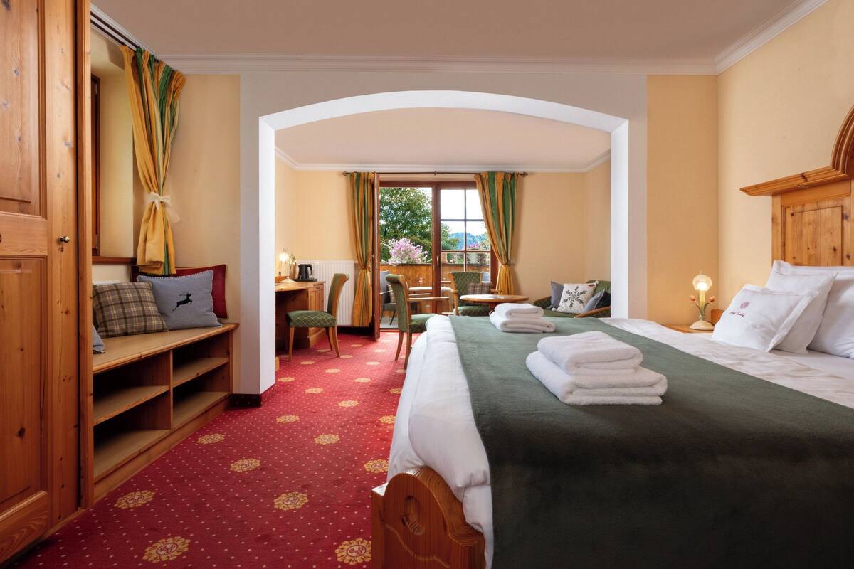 Une chambre d’hôtel avec un lit, un bureau, une chaise et une vue sur l’extérieur.