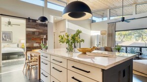 A modern kitchen with a large island, wooden ceiling, and pendant lighting. - Sundrenched by Avantstay Pool, Mins to Old Town (Scottsdale)