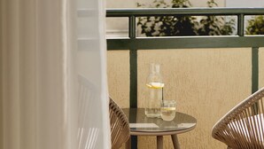 An outdoor balcony with a table and two chairs, a bottle, and a glass of water. - Stągiewna Residence by Downtown Apartments (Gdansk)