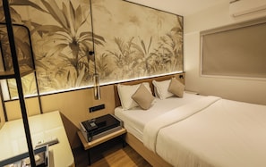 A hotel room with a bed, bedside table, lamp, and a large wall mural. - Hotel Western (Mumbai)