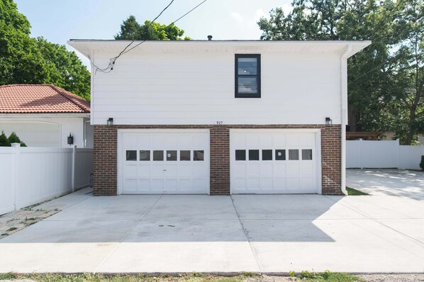 Et tosidet hus med garage, hvid facade og murstensfundament.