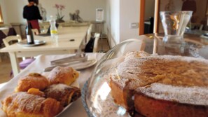A dining table with pastries and a glass display case. - AGRITURISMO B&B CASA BORTOLIN (Valdobbiadene)