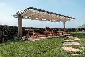 A covered outdoor seating area with benches and a pergola. - AGRITURISMO B&B CASA BORTOLIN (Valdobbiadene)