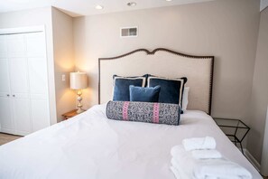 Cozy retreat with a neatly made bed, bedside table, and lamp.