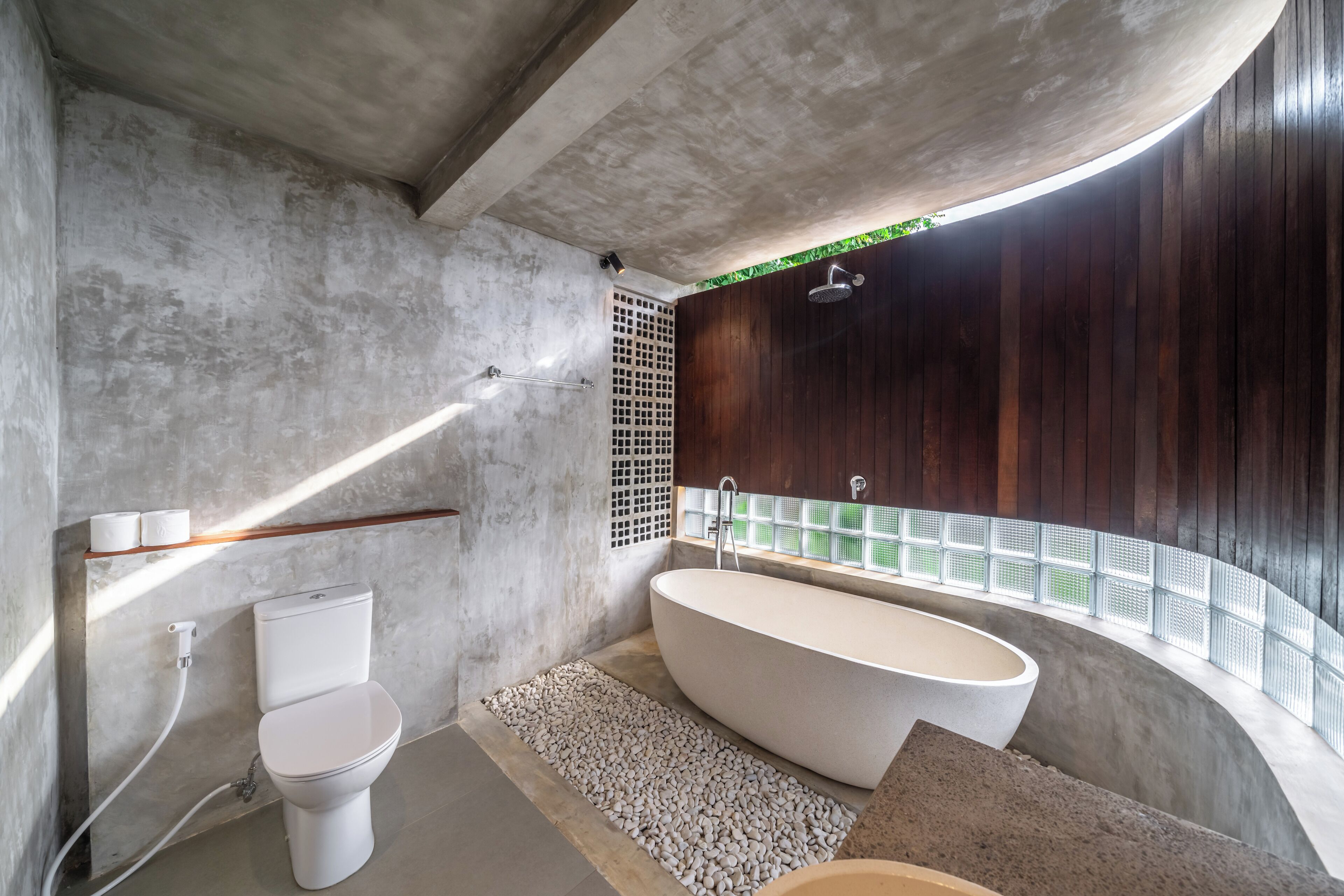 Une salle de bain moderne avec une baignoire sur pieds, des toilettes et un espace douche.