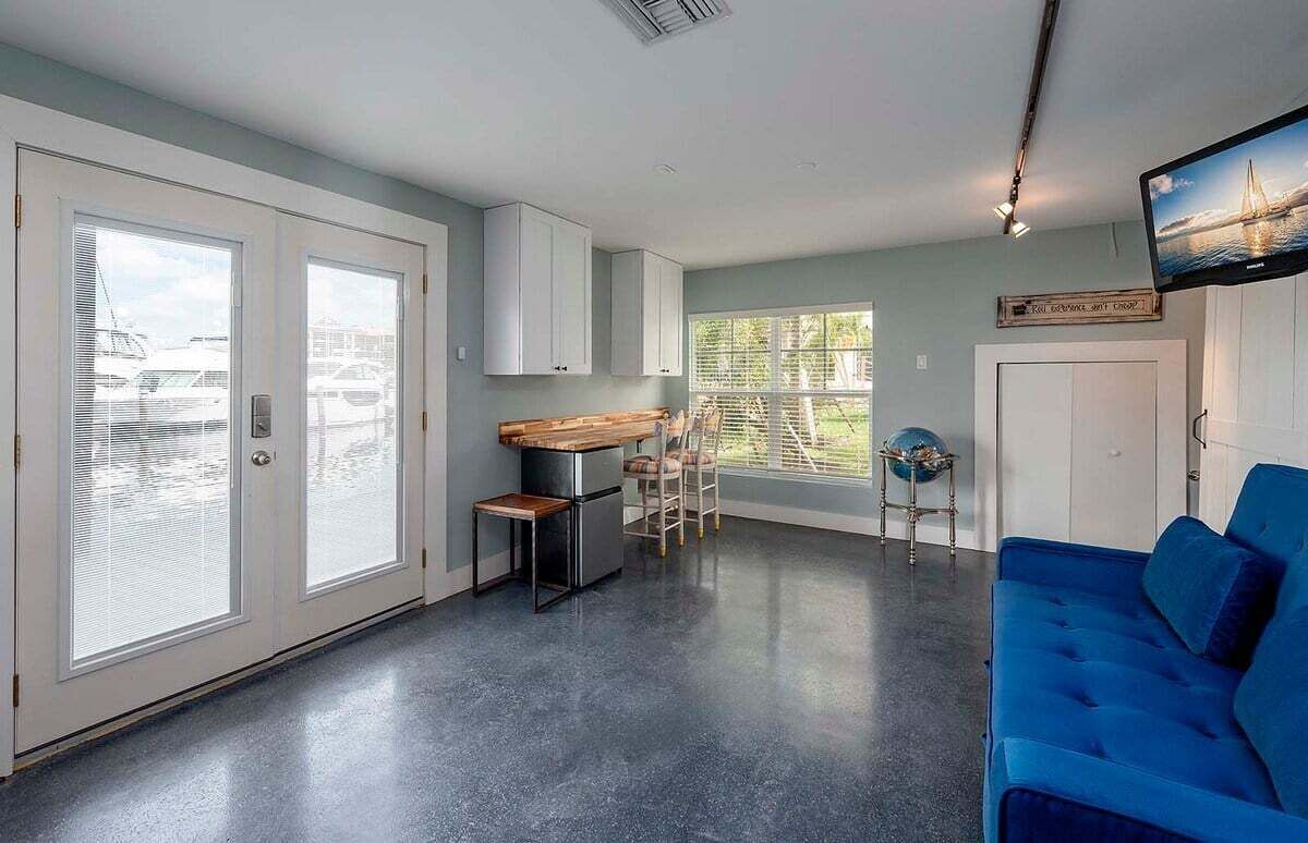 Una cocina moderna con armarios blancos, encimera de madera y un comedor con sillas.