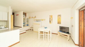 A compact living space with a kitchen, dining area, and a TV.