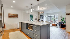 A modern kitchen with a large island, built-in oven, and pendant lighting. - Mountain-view Condo in Downtown Winter Park! (Winter Park)