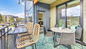 A balcony with wicker furniture, a table, and chairs, overlooking a residential area. - Mountain-view Condo in Downtown Winter Park! (Winter Park)