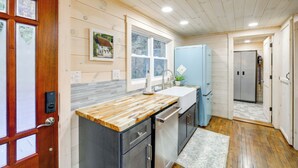 Una cocina con encimera de madera, electrodomésticos de acero inoxidable y un refrigerador azul.