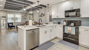 A modern kitchen with white cabinets, stainless steel appliances, and pendant lighting. - Ponte Vedra Beach Getaway w/ Patio! (Ponte Vedra Beach)