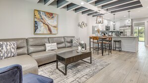 A modern living room with a sofa, coffee table, and artwork. - Ponte Vedra Beach Getaway w/ Patio! (Ponte Vedra Beach)