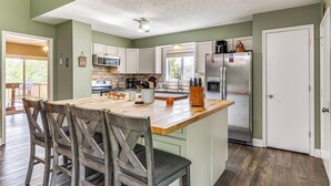 A kitchen with a wooden island, white cabinets, and stainless steel appliances. - Bloomington & Indy Area Gem: Near Attractions! (Martinsville)