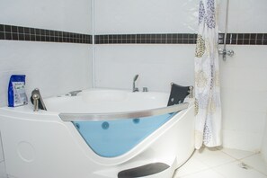 Bathroom features a bathtub and a shower curtain with floral patterns.