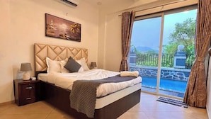 A spacious bedroom with a large bed, a ceiling fan, an air conditioning unit, a nightstand, and a view of a swimming pool through a glass door. - Scarlet By Stellar Stays (Mawal)