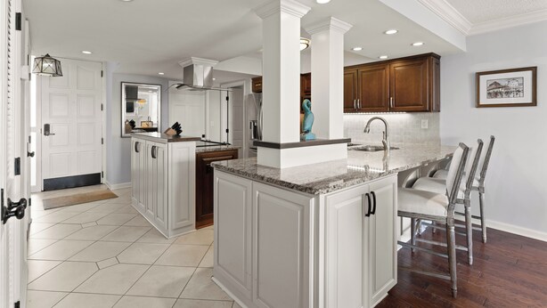 A spacious kitchen with white cabinetry, a granite countertop, and a large island. - King and Prince Villa (St. Simons Island)