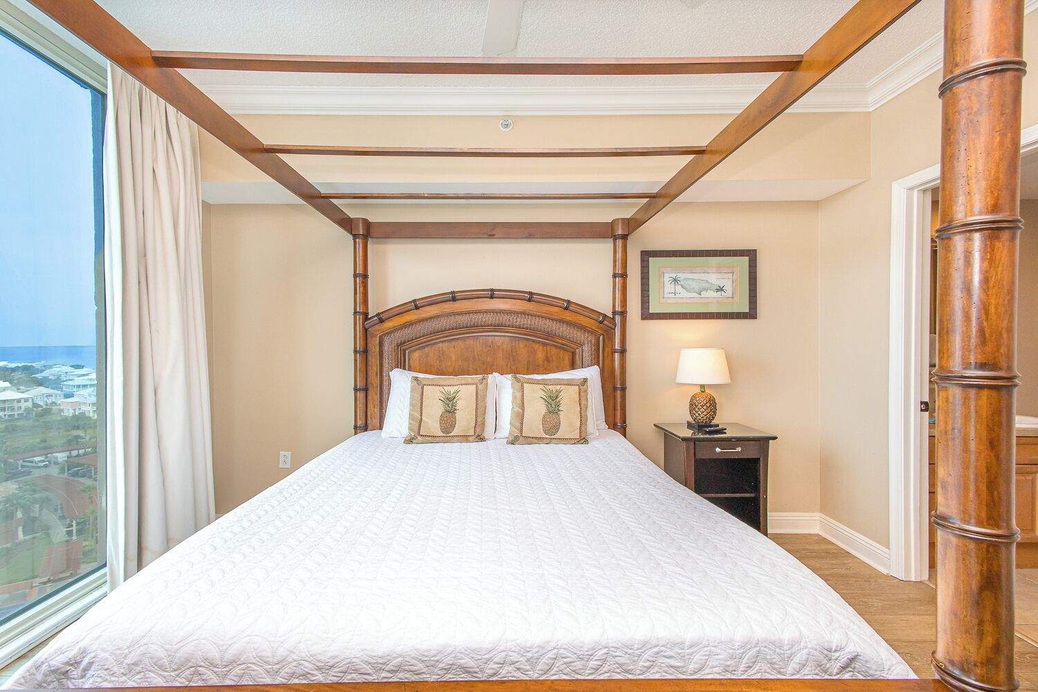 A hotel room with a large bed, wooden headboard, and a view of the city.