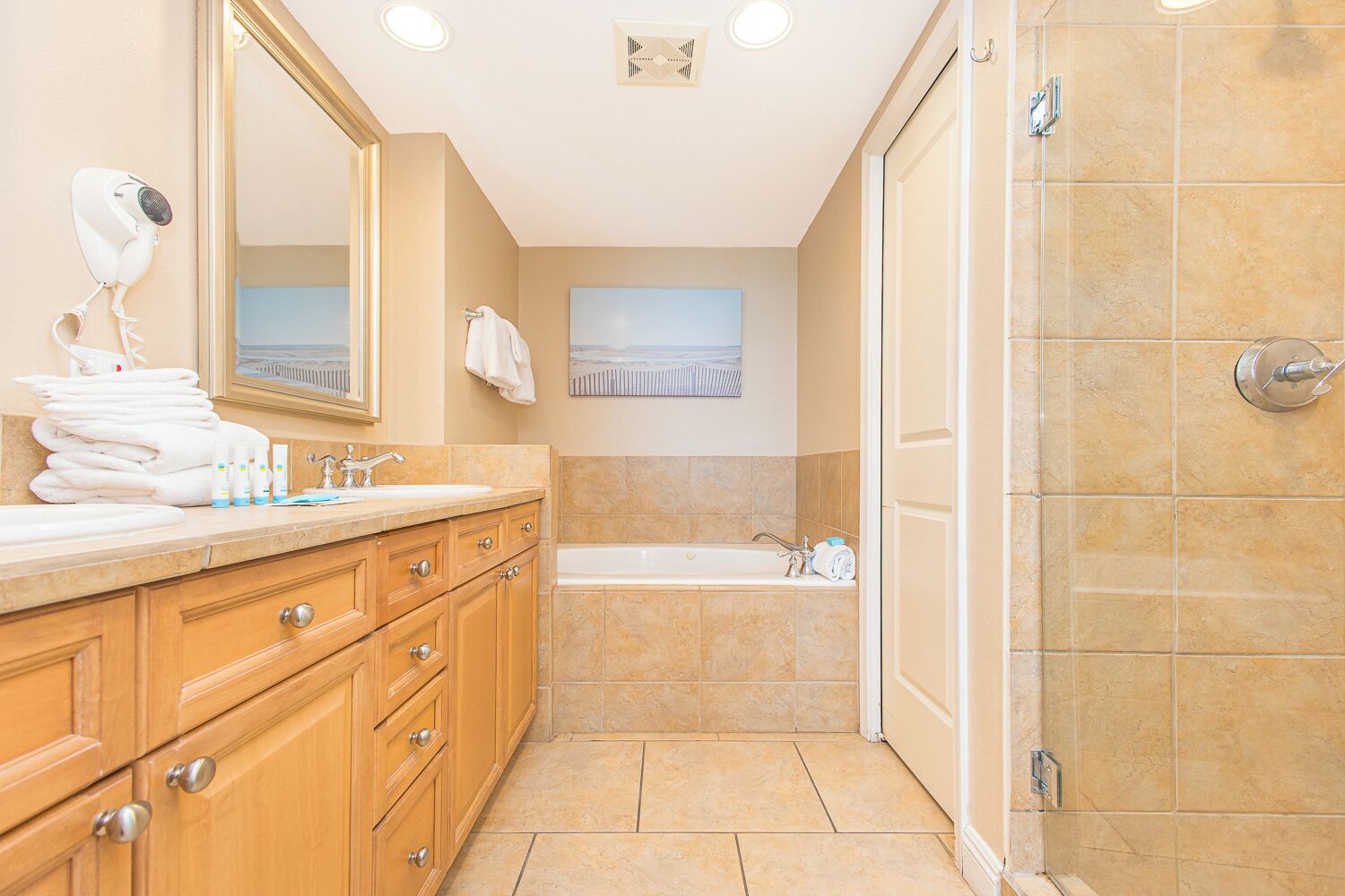 A modern bathroom with a large mirror, a sink, a bathtub, and a shower area.