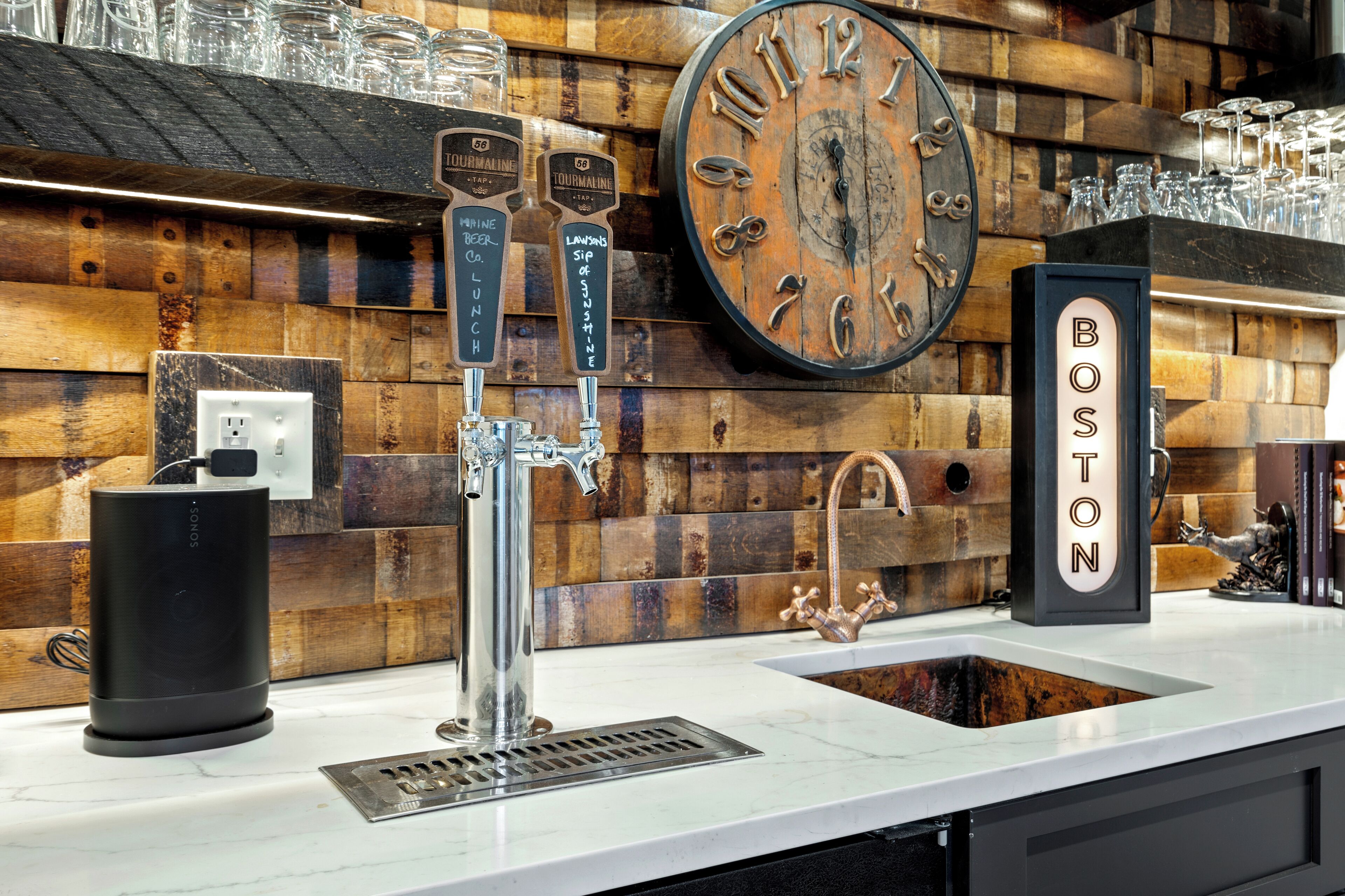Eine Bar mit einer Holzwand, einer Uhr und einem Schild mit der Aufschrift Boston.