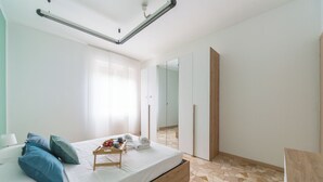 A modern bedroom with a bed, pillows, a tray with toiletries, and a large mirror. - Milan Style Apartment  (Milan)