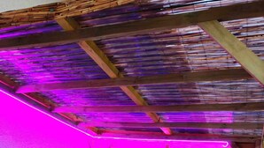 A hot tub in a wooden room with a sloped ceiling and pink lighting. - Former gatehouse, spa, billiards room near Beauval Zoo, Loire château. (Luçay-le-Mâle)