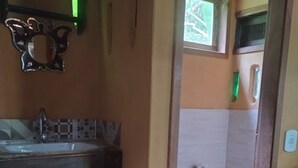 A small bathroom with a sink, toilet, and a decorative mirror. - ALDEA zen chalés e suítes privativos (Ouro Preto)