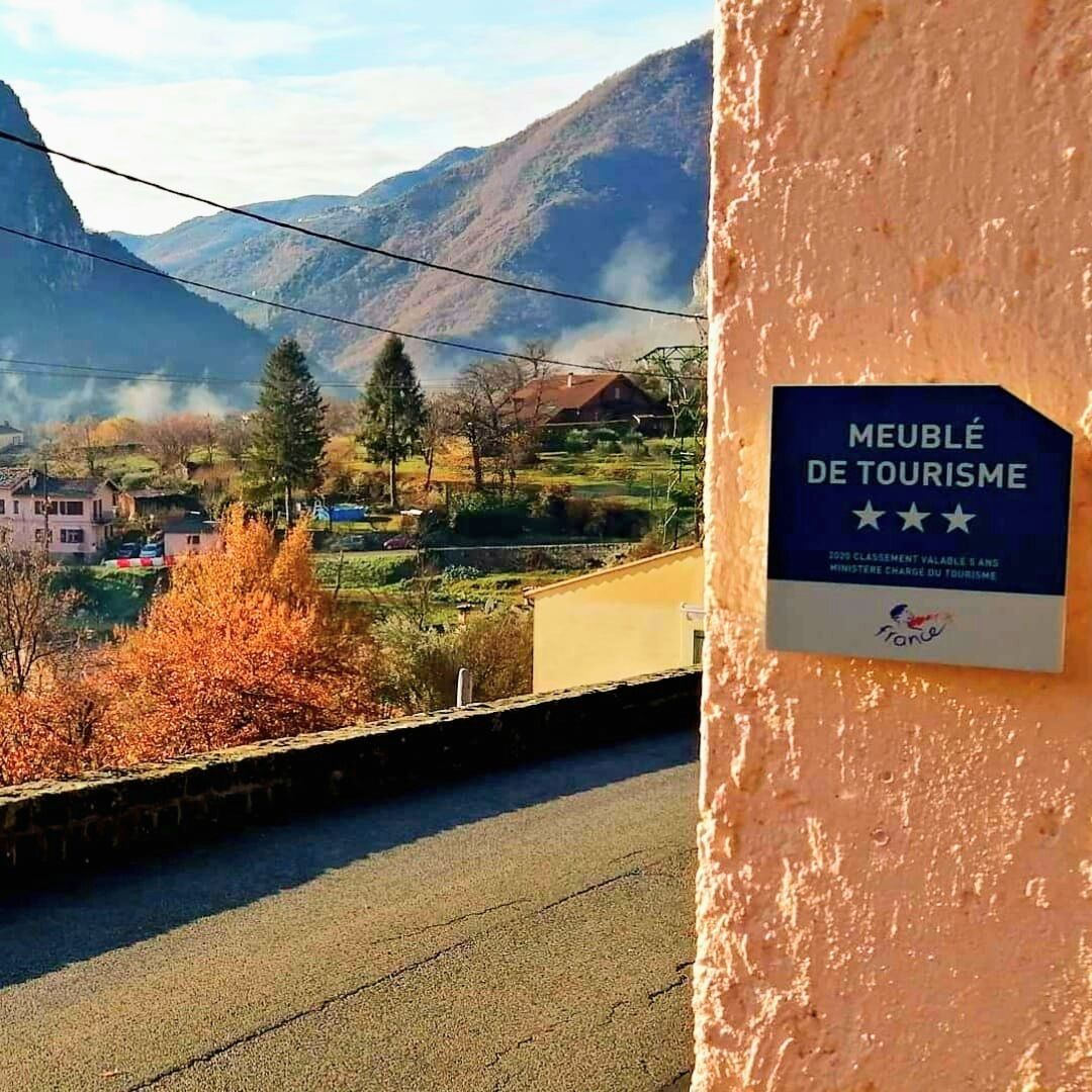 Une vue pittoresque d’un village de montagne, avec un panneau indiquant qu’il a reçu un prix dans le domaine du tourisme.