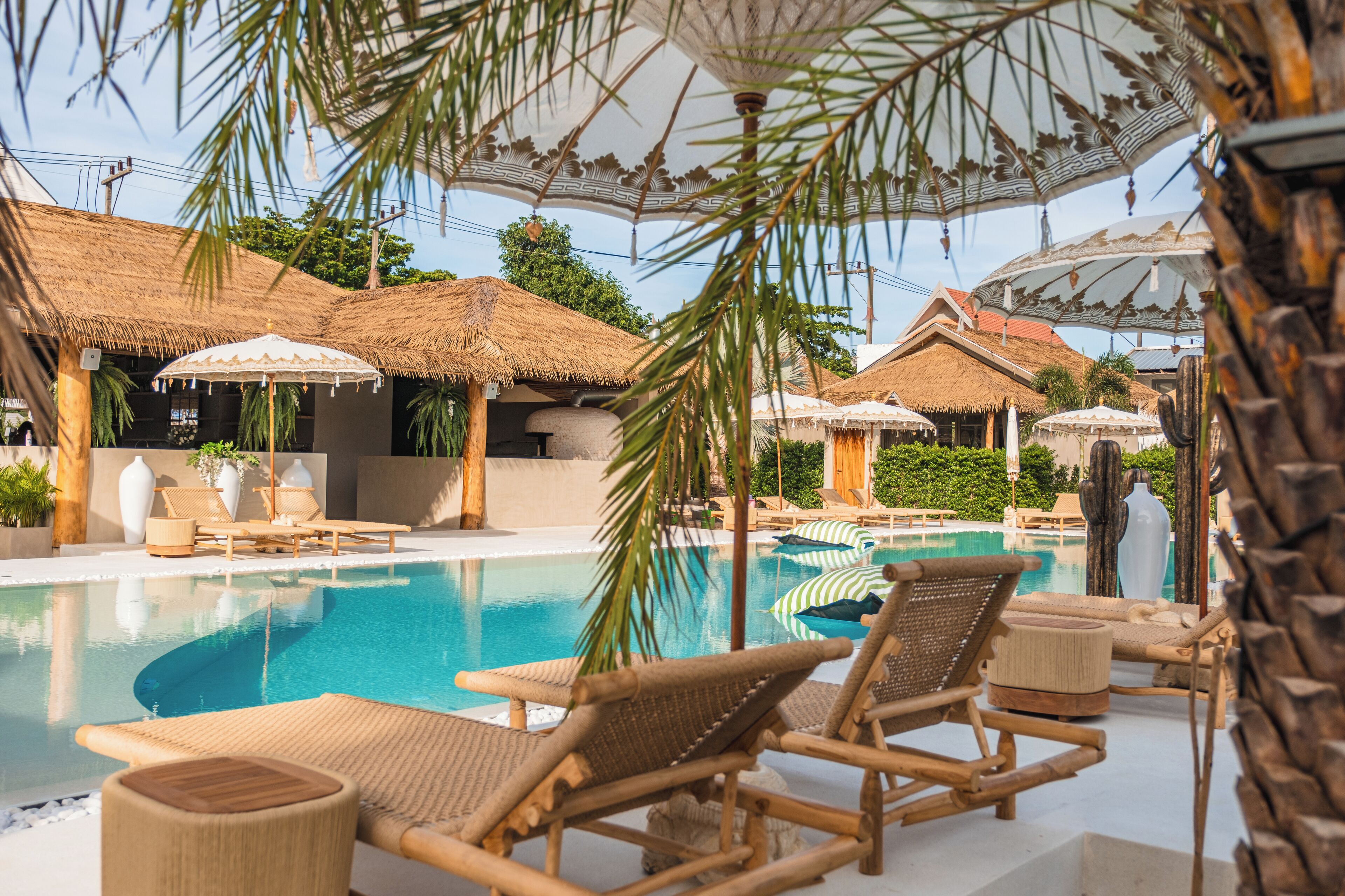 Uma área de piscina com espreguiçadeiras e guarda-sóis.