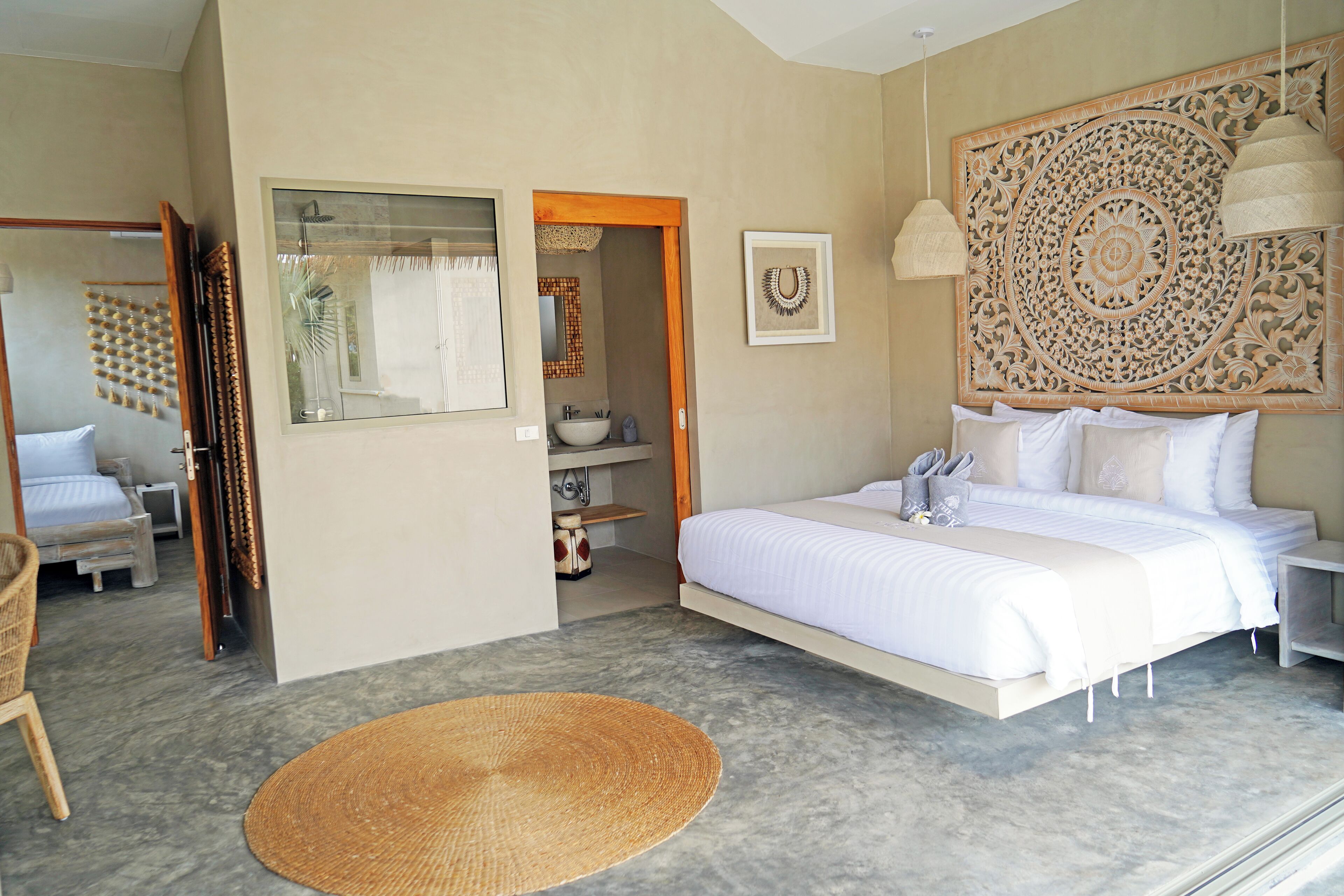 Un dormitorio moderno con una cama grande, un baño pequeño y vistas de la habitación.