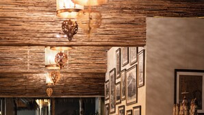 Une rangée de statues ornées de bougies, un plafond en bois, des tableaux encadrés accrochés au mur et une carte.