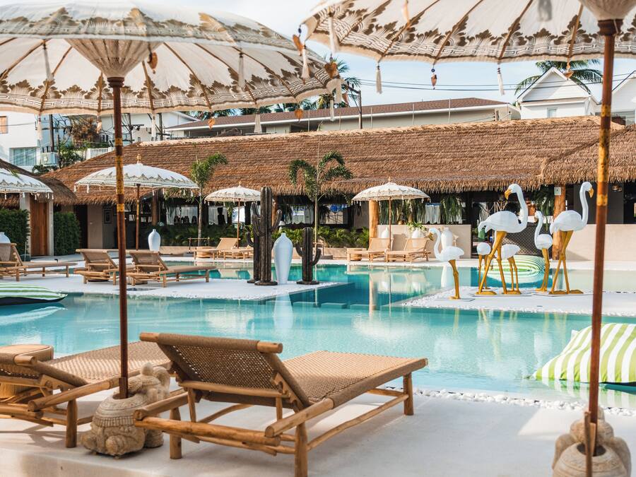 Ein Poolbereich mit Liegestühlen und Sonnenschirmen.